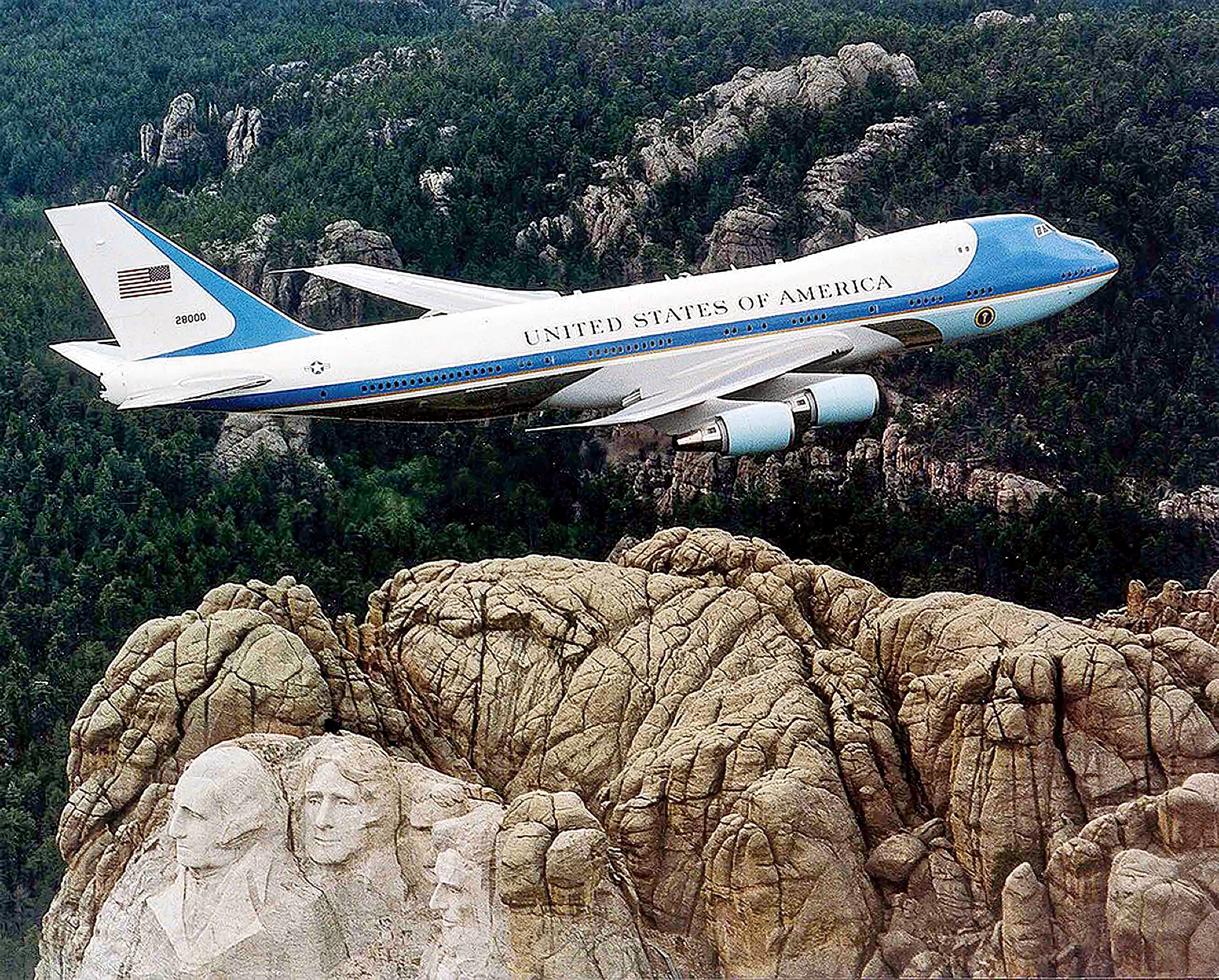 Air Force One, the typical air transport of the President of the United States of America, flying over Mount Rushmore February 10, 2001 (Air Force Photo, Wikimedia Commons).