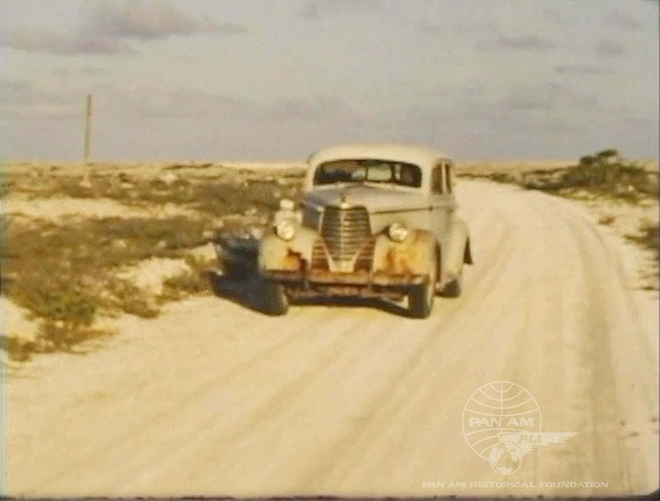 Film frame of automobile on Canton Island in the Pacific, footage shot by Peter Leslie. (Leslie Family Foundation).